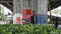 Salah seorang seniman sedang menghias salah satu tiang tol dengan mural bertema Asian Games.