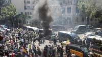 Peserta unjuk rasa melampiaskan kemarahannya dengan menendang mobil berwarna hitam yang diduga sebagai anggota Uber. Albert Gea/Reuters.