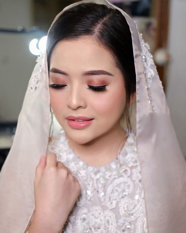 Riasan tampak natural dengan menonjolkan bagian mata menggunakan eyeshadow bronze dan bulu mata tebal. Foto: Instagram/@tasyakamila