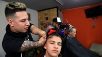 Meski tak memiliki tangan yang sempurna, keahlian Heredia tak perlu diragukan. Ia tampak luwes mengatur gaya rambut pelanggannya. Marcos Brindicci/Reuters.