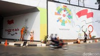 Sejumlah petugas Penanganan Prasarana dan Sarana Umum (PPSU) sedang menghias dinding jalan di kawasan Taman Mini, Jakarta, dengan mural, Sabtu (4/8/2018).