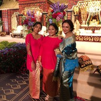 Pilihan busana untuk hadir di resepsi salah satu kerabatnya itu adalah kebaya biru terang berbahan lace, dengan potongan pundak terbuka sehingga membuatnya terlihat lebih seksi. Tata memadukan kebayanya dengan kain dan selendang songket Padang. Foto: Instagram/@tatacahyani