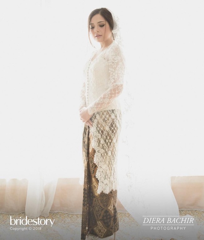 Kebaya putih lace dengan aksen bordir karya Andhita Siswandi membuat penampilan Tasya terlihat anggun dan cantik. Ia memadukannya dengan kain batik klasik. Tak lupa veil panjang yang menambah kesan dramatis. Foto: Instagram