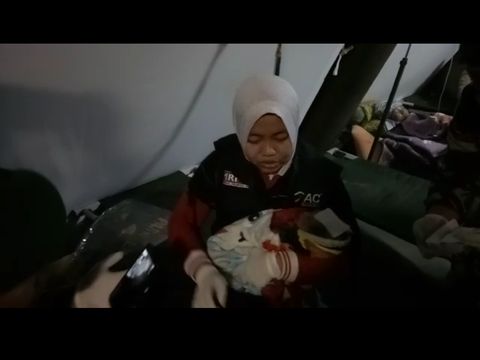 Seorang ibu melahirkan bayinya di tenda pos Yonkes Divisi I Kostrad Lombok Timur.
