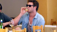  Duh, lagi minum apa, sih? Yang jelas, saat itu ia sedang berada di Italia dan gelas berukuran kecil itu makin terlihat kecil saat digenggam Liam. Foto: INFphoto  