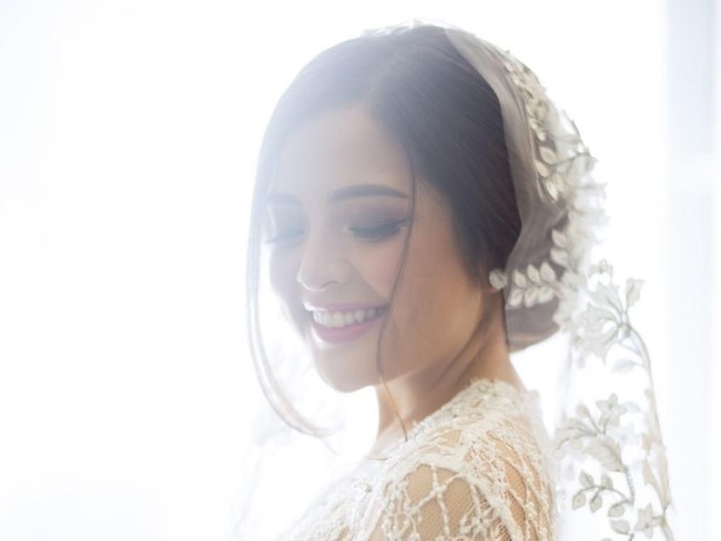 Sanggul sederhana dengan bagian depan rambut yang dibiarkan menjuntai, membingkai wajah imut Tasya dengan sempurna. Woko, adalah hairstylist di balik tatanan rambut wanita 25 tahun ini. Foto: Instagram/@thebridestory
