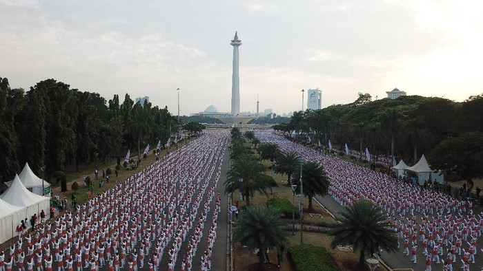 Ribuan warga melakukan senam poco-poco saat pemecahan rekor dunia senam massal poco-poco di Monas, Jakarta, Minggu (5/8). Kegiatan dalam rangka menyambut Asian Games 2018 itu diikuti 65 ribu peserta dari berbagai kalangan. ANTARA FOTO/Akbar Nugroho Gumay/ama/18