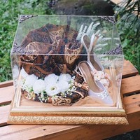 High heels berwarna silver menjadi seserahan berikutnya dari Randi untuk Tasya Kamila. Seserahan Indonesia mempercantik hantaran tersebut dengan hiasan kain batik. Foto: Instagram/@seserahanindonesia