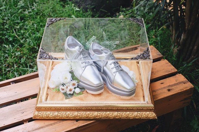 Akun Instagram Seserahan Indonesia mengunggah sederet foto yang memperlihatkan dekorasi hantaran lamaran Randi Bachtiar untuk Tasya Kamila. Pertama adalah sepatu dari brand Stella McCartney berwarna silver ini. Sepatu berharga belasan juta rupiah itu tampak ditata cantik dengan dekorasi bunga putih. Foto: Instagram/@seserahanindonesia