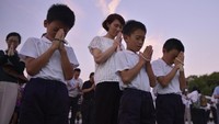 Sebuah bel dibunyikan di titik nol Taman Memorial Perdamaian Hiroshima tepat saat bom atom jatuh ke Hiroshima 73 tahun silam. Masa mengheningkan cipta lantas dilakukan dan warga Jepang berdoa secara khusyuk. Foto: Kyodo/via REUTERS