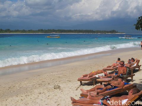 Turis berjemur di tepian pantai Gili Trawangan
