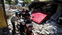 Warga bergotong-royong menyelamatkan sebuah sepeda motor (Foto: Dok. REUTERS/Beawiharta)