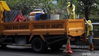 Petugas menyiapkan pompa dan air dari atas truk.