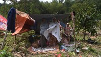 Pengungsi melaksanakan salat Dhuhur di dalam tenda darurat yang dibangun di kebun mereka di Lombok Barat, Nusa Tenggara Barat, Senin (6/8). ANTARA FOTO/Zabur Karuru.