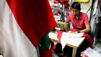 Seorang penjahit tengah menyelesaikan pesanan bendera Merah Putih di kawasan Pasar Senen, Jakarta, Senin (6/8/2018).