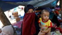 Potret seorang pengungsi bersama anak kecil berdiri di dekat tenda pengungsian di Pamenang (Foto: Dok. REUTERS/Beawiharta)