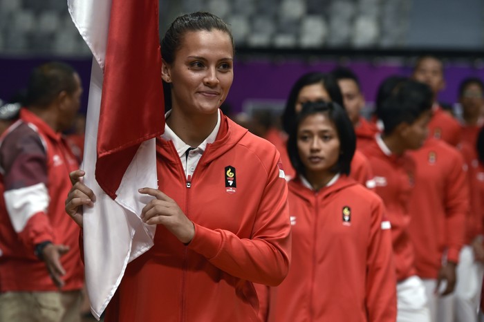 Atlet Jiu Jitsu Indonesia Simone Julia memegang bendera Merah Putih saat upacara pengukuhan kontingen Asian Games XVIII di Istora Senayan, Jakarta, Minggu (5/8). Kontingen Tim Indonesia yang terdiri dari 940 atlet dan 366 ofisial merupakan kontingen terbesar sepanjang sejarah keikutsertaan Indonesia di turnamen olahraga. ANTARA FOTO/Puspa Perwitasari/kye/18