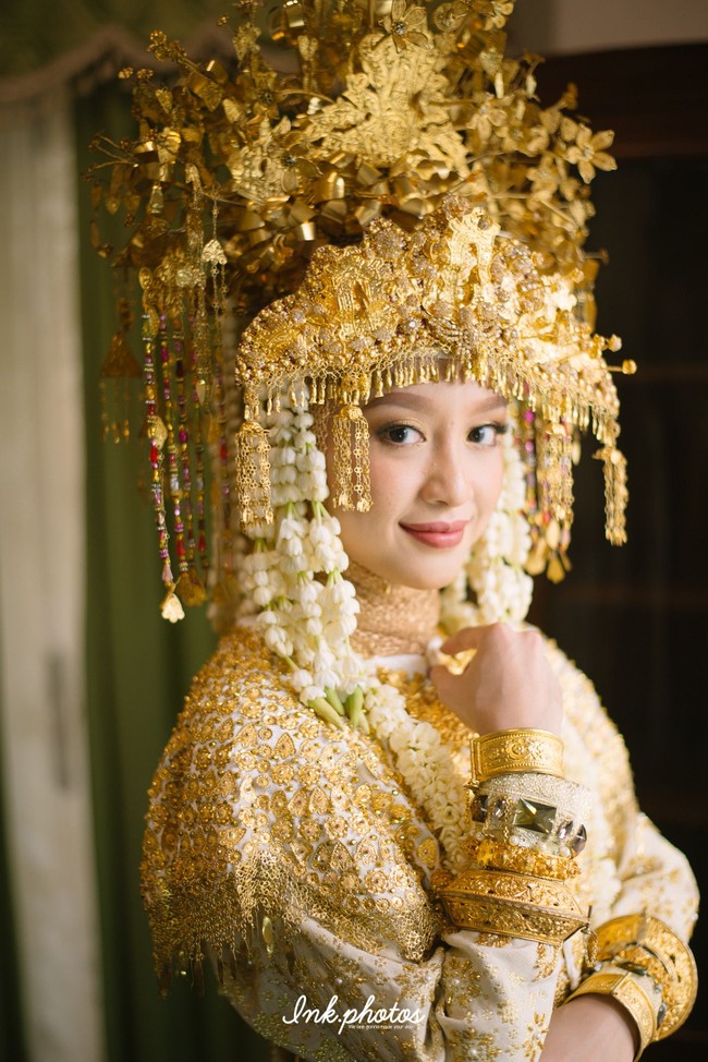 Saat akad nikah, Gita mengenakan busana adat Palembang lengkap dengan mahkota yang cantik. Ia tampak anggun memakai busana bernuansa keemasan itu.  Foto: Dok. Ink Photos (Instagram @ink.photos)