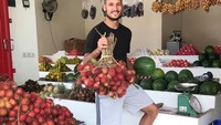 Pria keturunan Bukittinggi ini, berkunjung ke pasar yang ada di Madura, untuk membeli seikat buah rambutan yang masih segar. Foto: Instagram @raphaelmaitimo