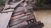 Tampak terlihat jembatan lapuk dengan tiang penyanggah dari kayu. Lokasi jembatan ini berada di Desa Teluk Kiambang, Tempuling, Inhil.