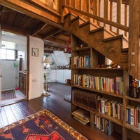 Bagian bawah tangga yang difungsikan sebagai perpustakaan kecil. Bisa jadi ide untuk menata rumah kamu sendiri, nih. Foto: Dok. Airbnb