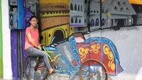 Warga berfoto di mural yang ada di kampung tematik Penjaringan, Jakarta Utara, Senin (6/8/2018).