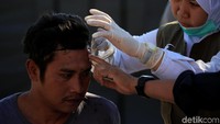 Paramedis membersihkan kepala seorang warga yang terluka. REUTERS/Beawiharta.