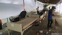 Pekerja mulai membersihkan lapangan parkir yang sebelumnya digunakan untuk merawat pasien.