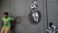 Anak-anak bermain di mural Kampung Tematik Penjaringan.