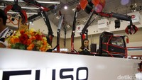 Model berpose di dekat truk robot Laba-laba milik Fuso.