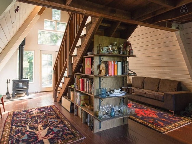 Pemilik kabin ini secara bertahap merenovasi bangunan sehingga menjadi penginapan yang nyaman dan unik untuk ditempati. Ini bagian bawah kabin mungil yang dilengkapi ruang santai serta dapur. Foto: Dok. Airbnb