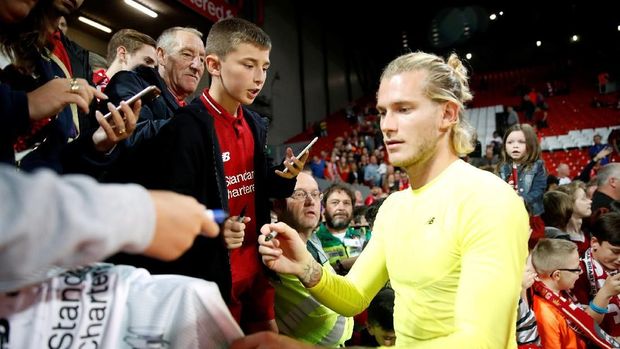 Karius membalas penghormatan suporter dengan memberikan tanda tangan.