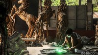 Salah seorang perajin sedang melakukan pengelasan untuk membuat patung kuda besi kayu.