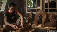 Salah seorang perajin sedang mengolah tanah liat menjadi sebuah kerajinan seni. Kemampuan para perajin ini tak perlu diragukan lagi. Salah satu hasil karyanya adalah kerajinan seni berbentuk naga yang dibuat oleh perajin dari tanah liat.