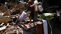 Warga mengambil barang-barang yang bisa diselamatkan untuk dibawa ke pengungsian. REUTERS/Beawiharta.