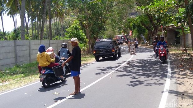 Warga di Dusun Pandanan, Pamenang, Lombok Utara meminta sumbangan dari pengendara, Rabu (8/8/2018)