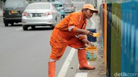 Seorang petugas melakukan pengecatan.