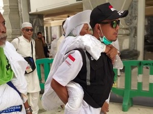 Petugas Bopong Jemaah Osteoporosis yang Kelelahan Setelah Tawaf
