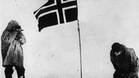 Roald Amundsen bersama para awak kapalnya berhasil mencapai Kutub Selatan dalam ekspedisi yang berlangsung pada 1910-1912. Amundsen terlihat mengebarkan bendera Norwegia usai mendaratkan kaki di wilayah yang dipenuhi dengan salju tersebut. Imagno/Getty Images.