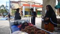Seorang pasien terbaring dengan tangan diinfus.