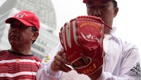 Imam Nahrawi mengecek sarung tangan untuk atlet sofbol. 