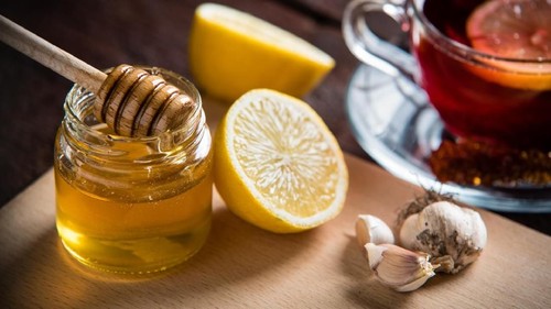 Honey in jar with honey dipper on vintage wooden background