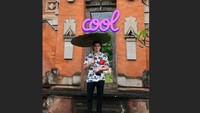 Foto: Putra sulung David, Brooklyn juga tak ketinggalan masuk Instastory ayahnya. Brooklyn tampak santai mengenakan kemeja pantai sembari memegang payung dan berfoto di depan sebuah gapura khas Bali. (David Beckham/Instagram)