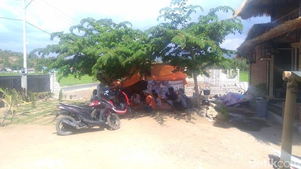 Keluarga yang mengungsi sementara di halaman rumah di Desa Karang Sobor, Kecamatan Tanjung, Lombok Utara pasca gempa 6,2 SR, Kamis (9/8/2018)