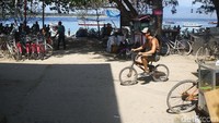Seorang turis bersepeda di Gili Trawangan.