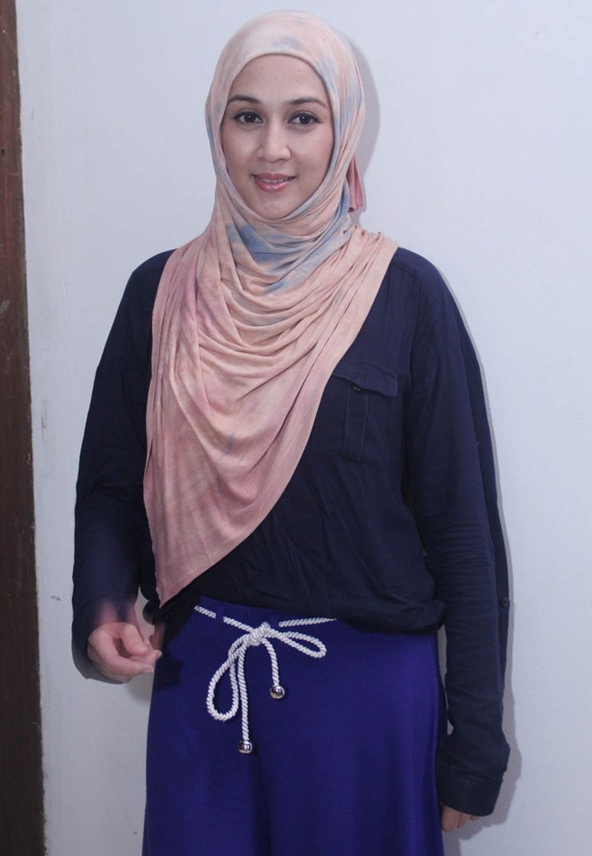 Hijab bercorak pelangi yang dipopulerkan oleh desainer Dian Pelangi juga pernah dicoba oleh Dina Lorenza. Ia tampil kasual dengan kemeja biru dongker dan celana berwarna senada. Foto: Istimewa