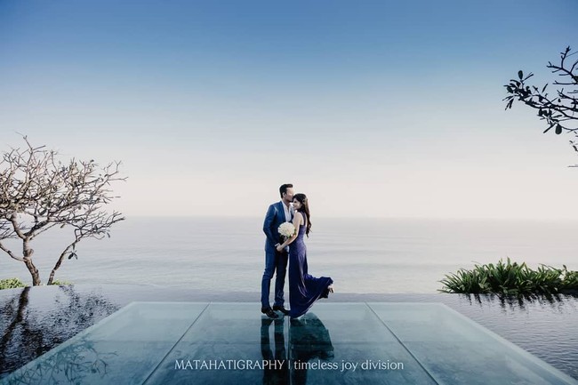 Dita Soedarjo dan Denny Sumargo berpose mesra di pinggir kolam renang. Keduanya tampil serasi dalam balutan busana formal saat berfoto di Bvlgari Resort Bali. Foto: Instagram @matahatigraphy