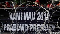 Salah satu poster yang dibawa para buruh di halaman depan KPU, Jakarta.
