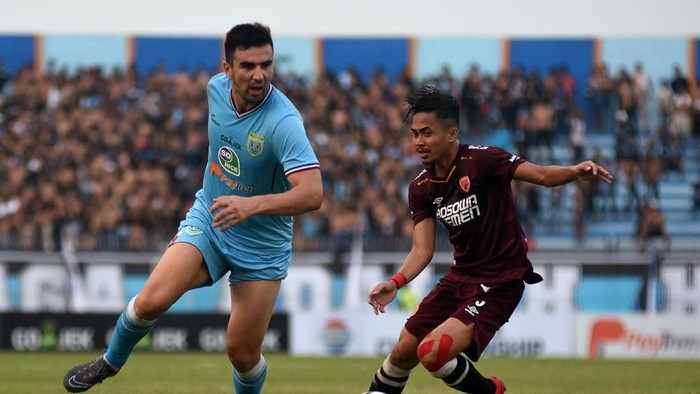 Pesepak bola Persela Lamongan Ahmet Atayev (kiri) berusaha melewati hadangan pesepak bola PSM Makassar Reva Adi Utama (kanan) dalam laga lanjutan Liga 1 di Stadion Surajaya, Lamongan, Jawa Timur, Jumat (10/8). Persela bermain imbang dengan PSM dengan skor 1-1. ANTARA FOTO/M Risyal Hidayat/kye/18