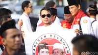 Beberapa orang yang hadir terlihat memakai baju koko putih dan syal merah yang dikalungkan di leher.